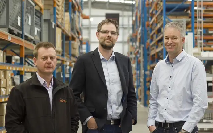 A group of men standing in a warehouse