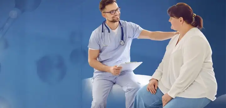 Male doctor comforting female patient in consulting room