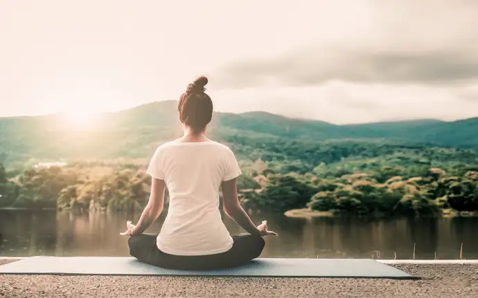 Frau in Yogaposition, die auf den Horizont blickt