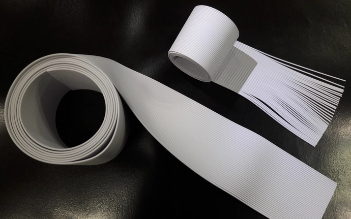 Zwei Rollen weißer Latexfäden