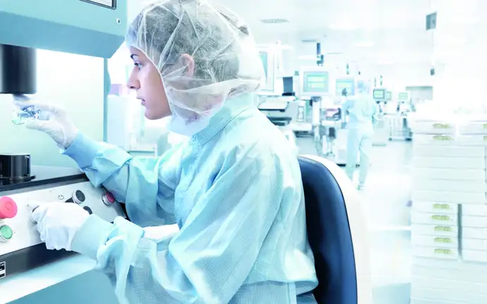 Female scientist inspects a glass vial in a laboratory