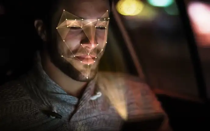 Man in a car looking at a smartphone with face-mapping technology