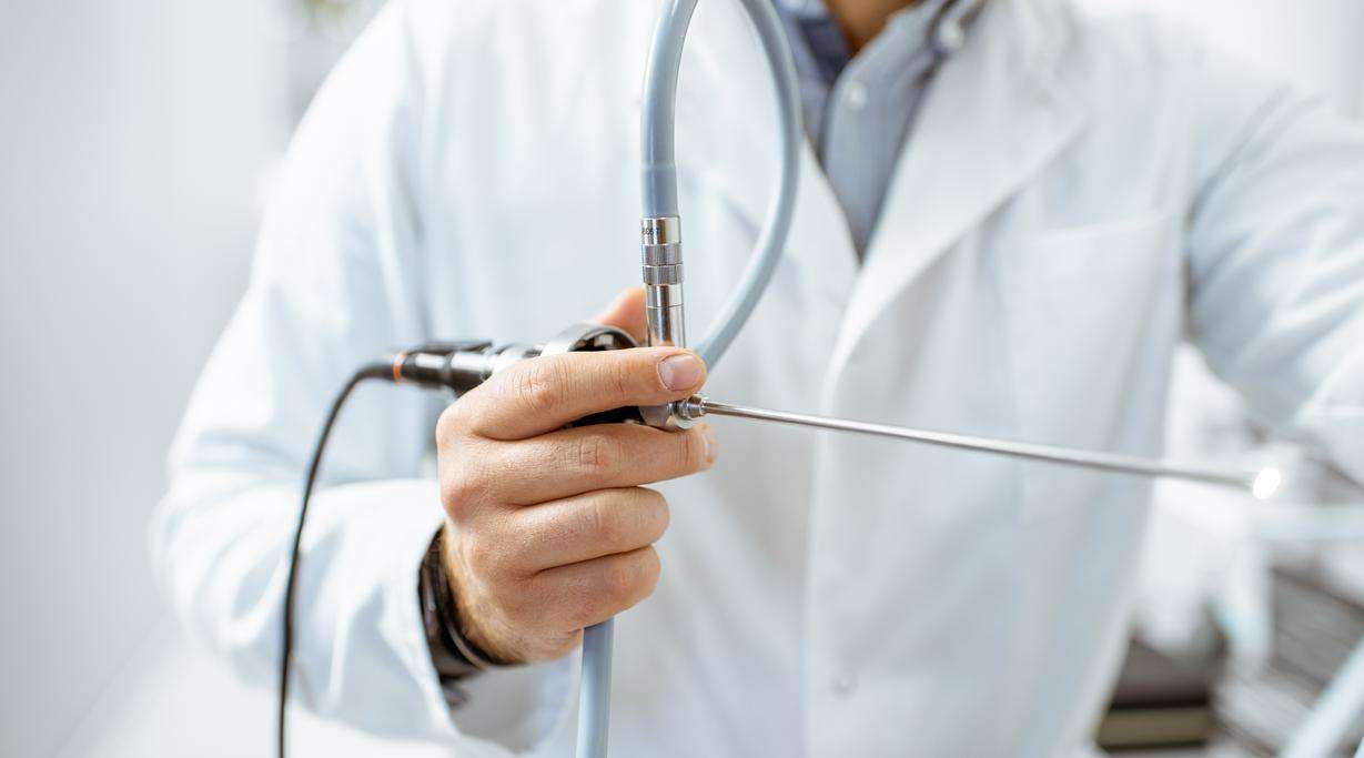Doctor in white coat holding an endoscope