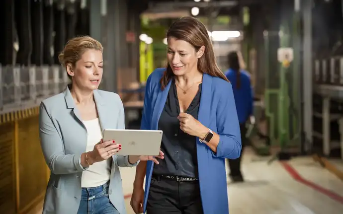 Duas mulheres na produção olhando para um tablet