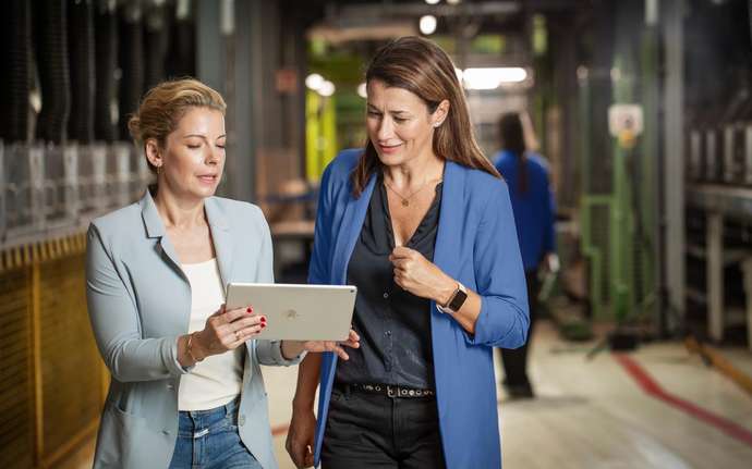 Two women in the production looking at an tablet