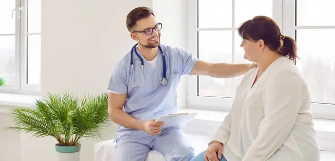doctor comforting female patient in consulting room
