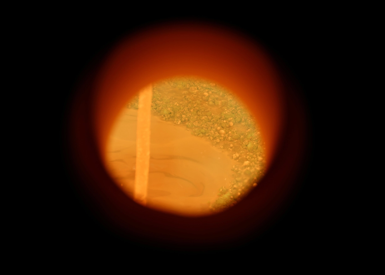 View into the melting tank with liquid glass at up to 1,700 degrees.