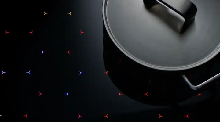 Topf auf einer Kochfläche mit farbigen Lichtelementen 