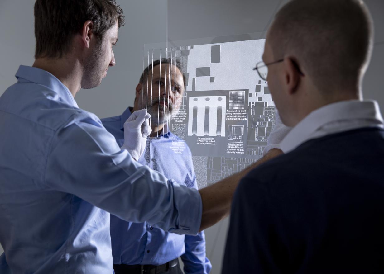 Trois hommes inspectant un panneau en verre micro structuré FLEXINITY® connect ultrafin