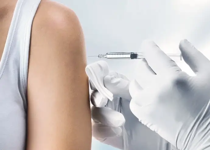   Arzt, der einem Patienten ein Medikament durch eine Spritze injiziert