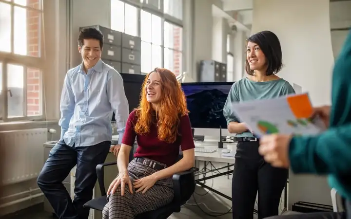 Work colleagues chat during a meeting