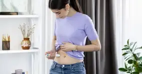 Women sitting in living room injecting drug via large-volume autoinjector.
