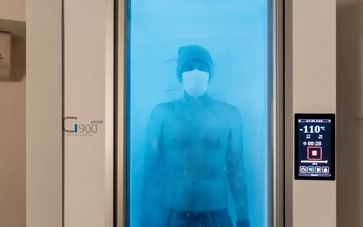 Man in a very low temperature cryotherapy chamber with SCHOTT Termofrost® glass door system maintaining the extreme cold.