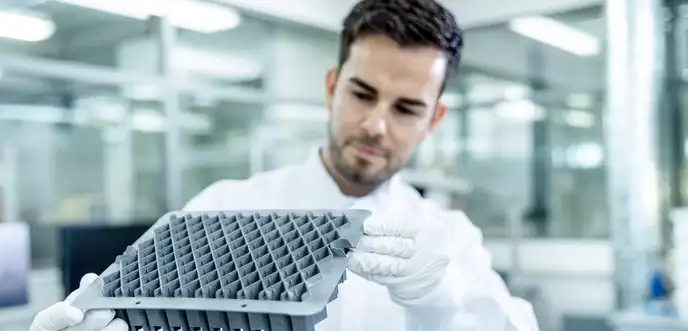 Homens inspecionando o protótipo de um berço em laboratório