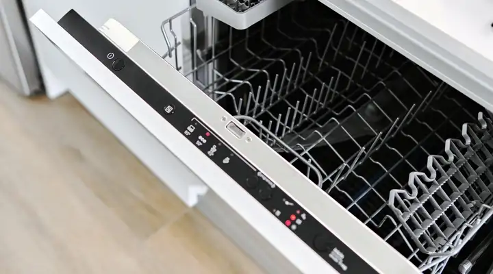 Open built‑in dishwasher with visible control panel made of glass and empty racks.