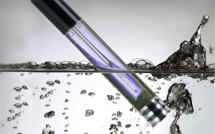 Long, thin lamp being plunged into water