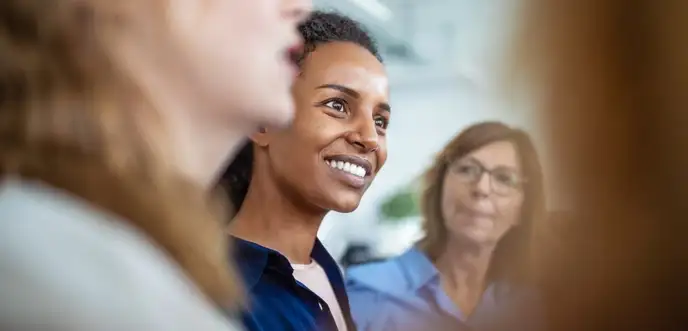 Tres mujeres hablando en una reunión de trabajo