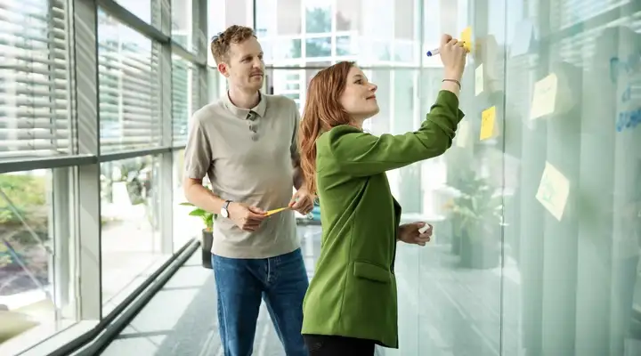 Women and Man standing on a whiteboard