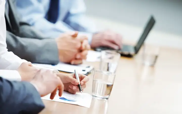 Close up of hands around a business conference table