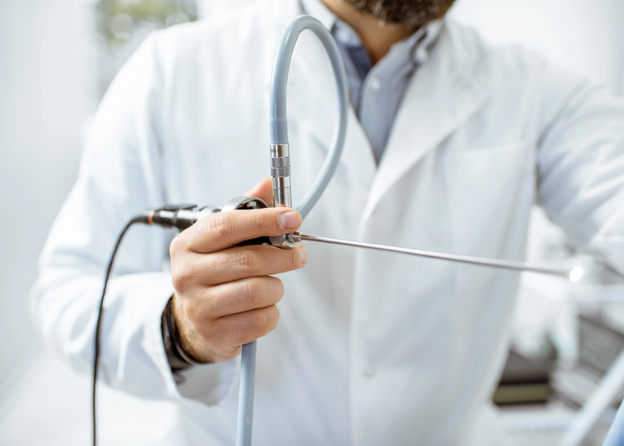 Male doctor holding a silver endoscope