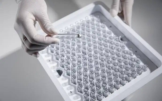 Gloved hands hold a cartridge and a cartridge holder.