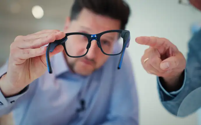 两名工作人员共同查看配备几何反射波导的眼镜