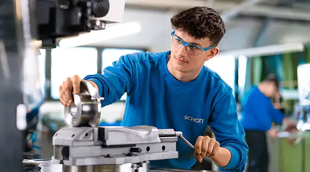 Eine Person bedient eine große Metallbearbeitungsmaschine in einer Werkstatt.