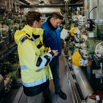 Two men check on the hydrogen mix to the SCHOTT glass melt