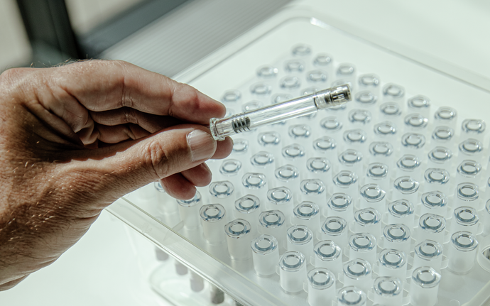 Man holding a prefillable polymer syringe.