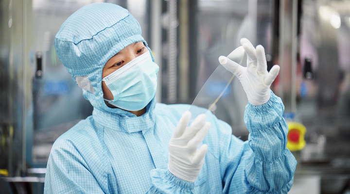 A scientist working in a laboratory looking at mirror discs