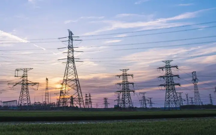 Rows of electrical pylons with sunset background