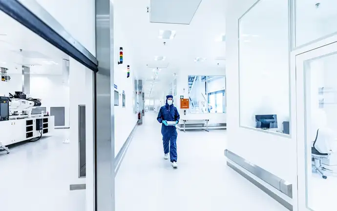 Employee walking through SCHOTT TOPPAC production hallway