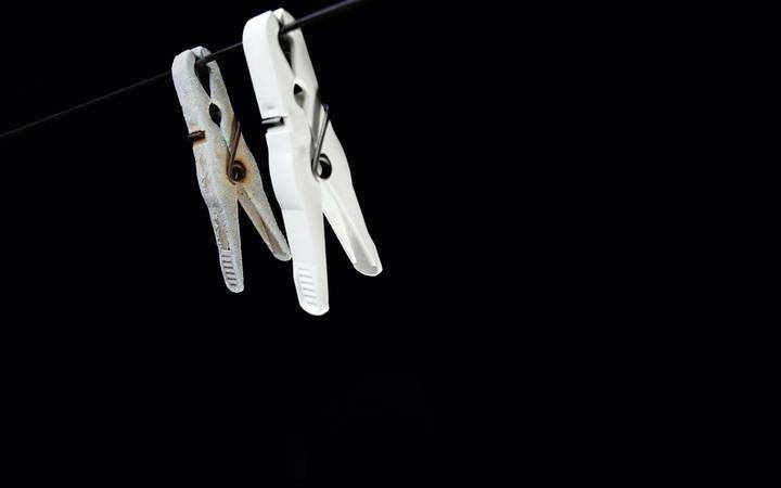 A pair of clothespins on a black wire