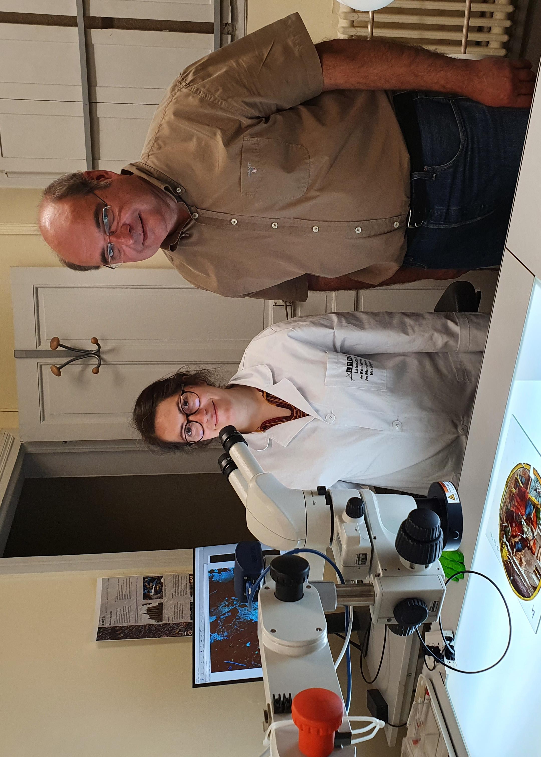 LRMH のエンジニアであるバーバラ・トリシェレオと、ステンドグラスサンプルの前にある顕微鏡部門の製品マネージャー、ギルス・ヴァイラント。