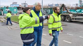 Anke Reining, Marco Müller and Marius Amschler walking outside in yellow safety jackets	