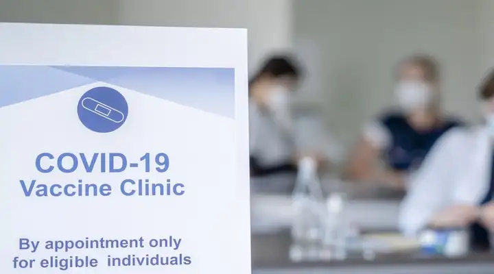 Healthcare Professionals giving vaccine shots out of e.g. a SCHOTT vial in a COVID-19 vaccination center