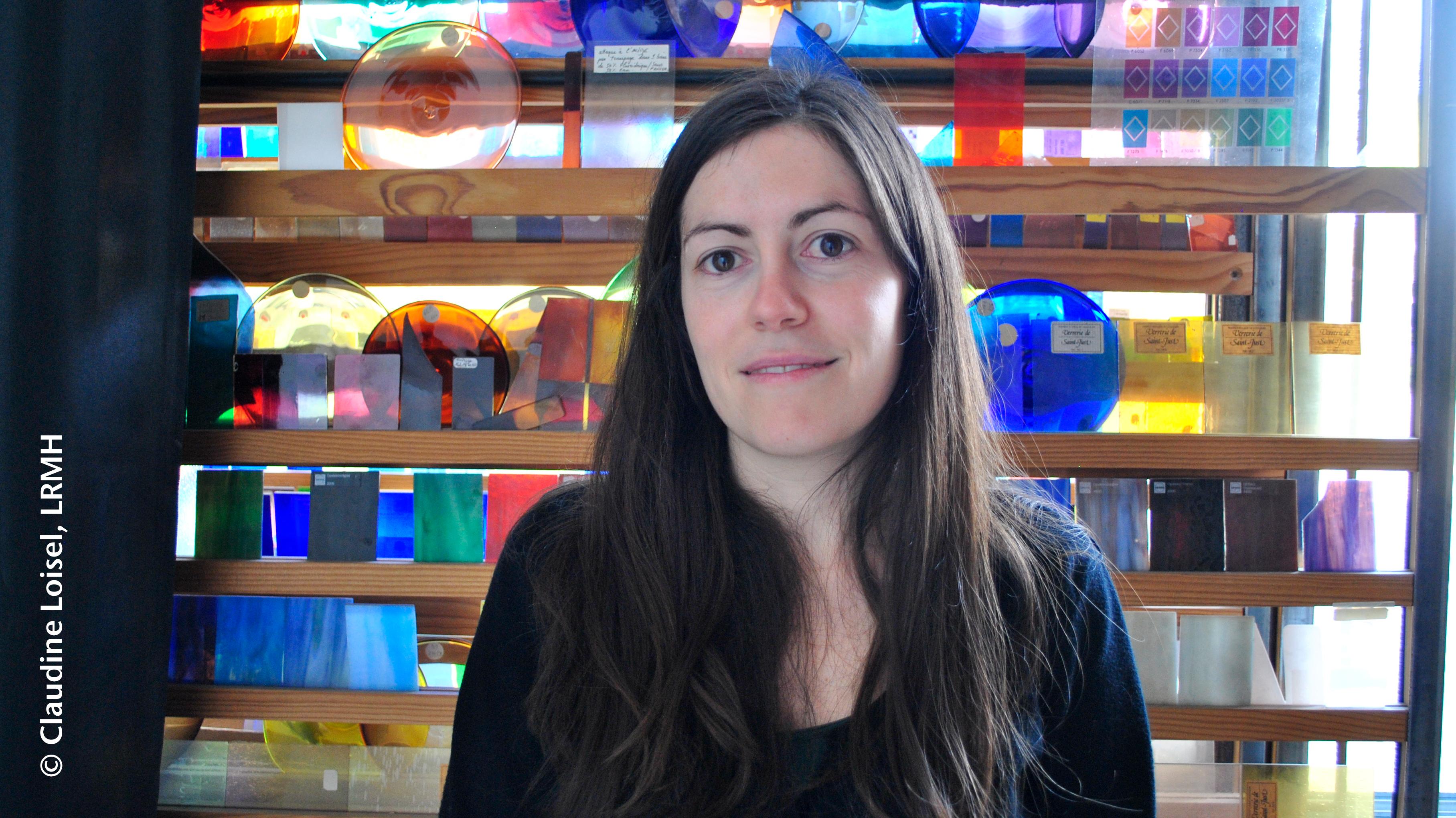 Barbara Trichereau in front of stained glass pieces