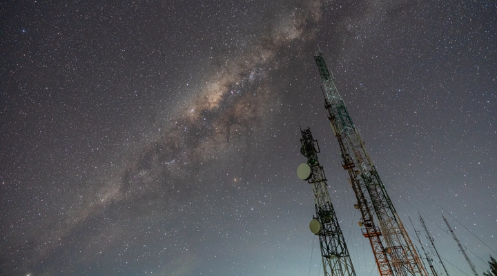 Mobile communications masts against a dark sky