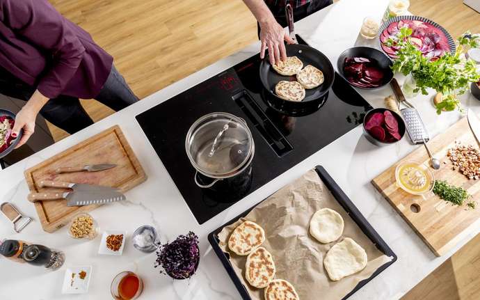 A healthy meal is prepared on a SCHOTT CERAN cooktop by two people