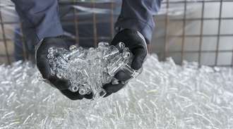 Employee holds a pile of unused medicine vials in his gloved hands	