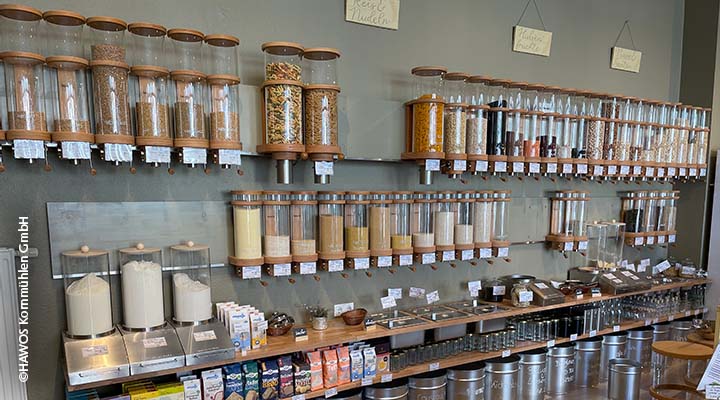Interior of a hawos store with line of glass tubes containing dry goods on wall