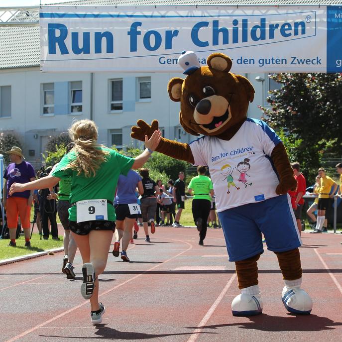 Bear high-fives child running in the SCHOTT Run for Children event 