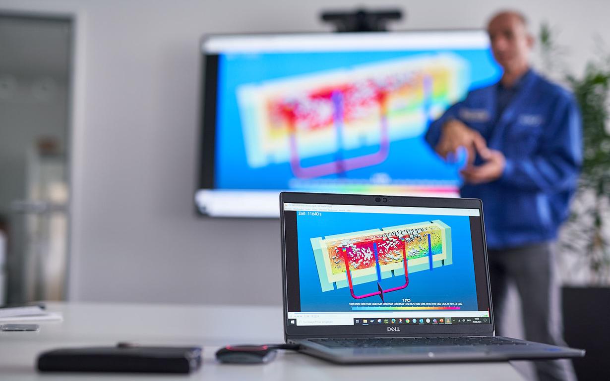 Man in front of laptop with the digital model of the melting tank changes