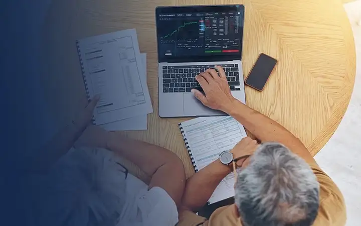 Elderly couple reviewing financial documents on a laptop