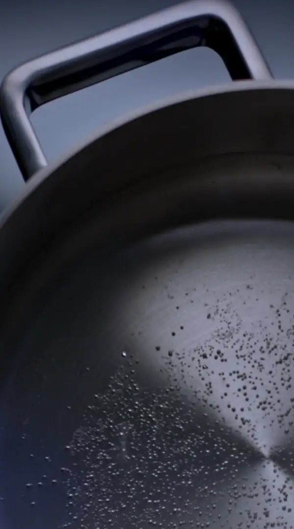 Topf mit heißem Wasser auf einer CERAN®-Kochfläche mit roten Lichtstreifen.