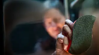 Man cleaning a sooty fire-viewing panel