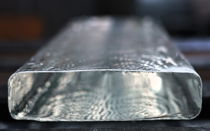 Rounded clear glass cube with ridges in it. 