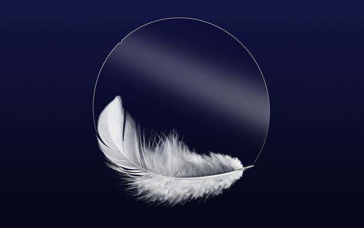 Lightweight glass wafer and feather with dark blue background