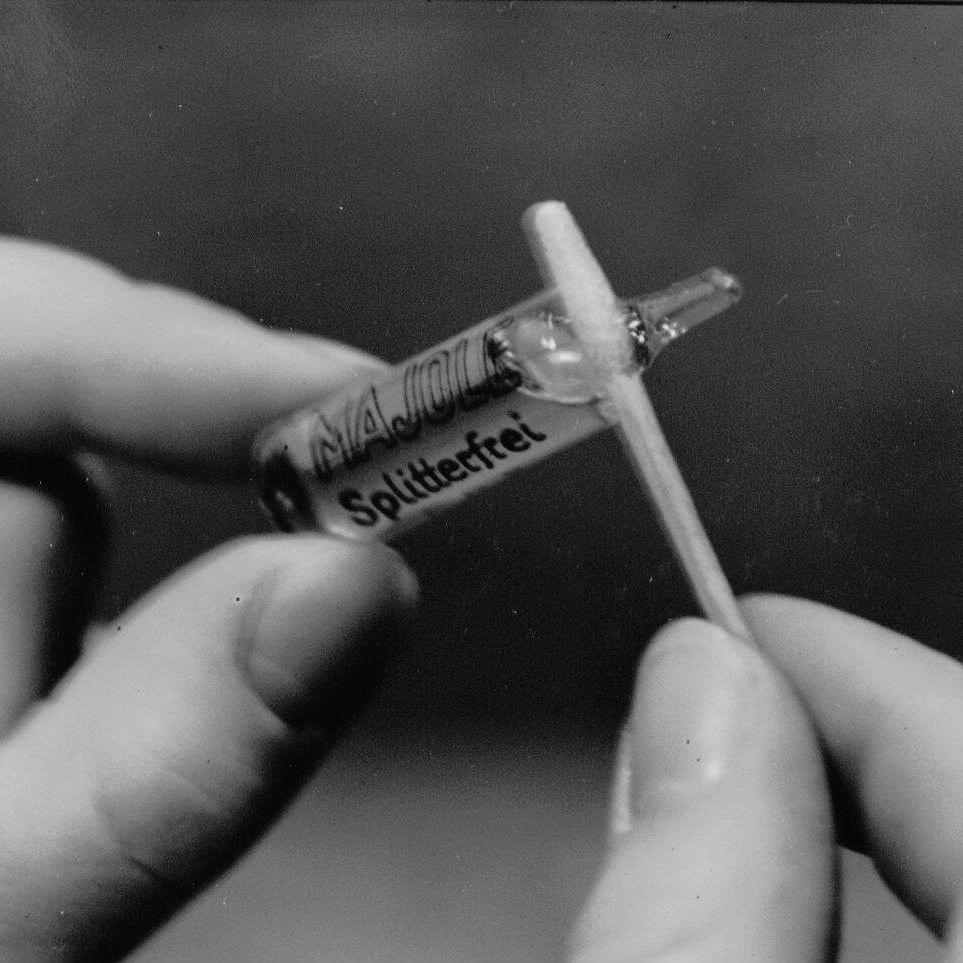 Hands holding a historical glass syringe	