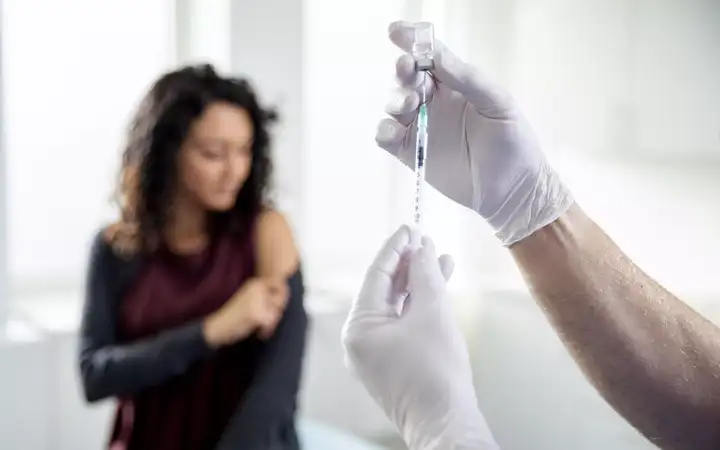 Female in a doctor’s surgery about to receive an injection